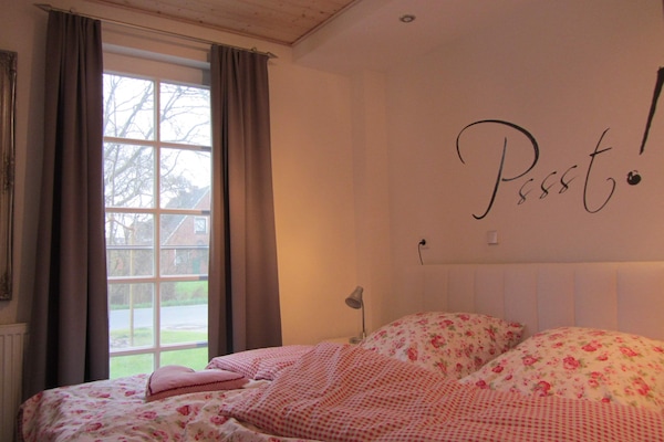 Gemütliches Schlafzimmer mit Doppelbett und Fernseher