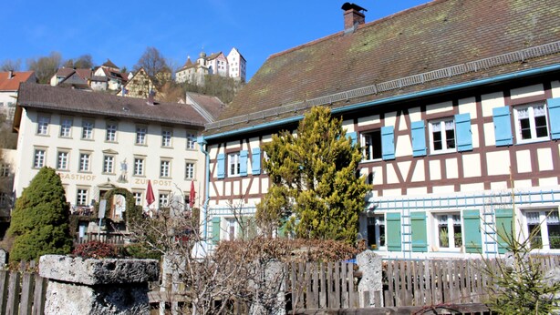 A traditional half-timbered building with a visible chimney, a stone wall, and a tree in the foreground. - Category C: 3-room apartment for 4 persons - Pension Mühle (Egloffstein)