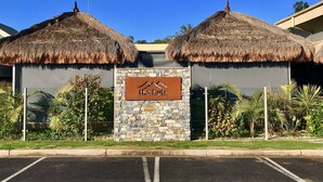 Um edifício com uma placa que diz "the huts" e estruturas com telhados de palha.