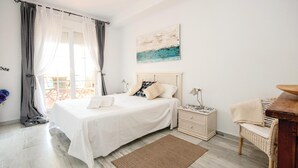 Una camera da letto con un letto, un comodino, una lampada e vista sull'esterno.