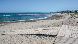 Una playa con un muelle de madera que conduce a la orilla.