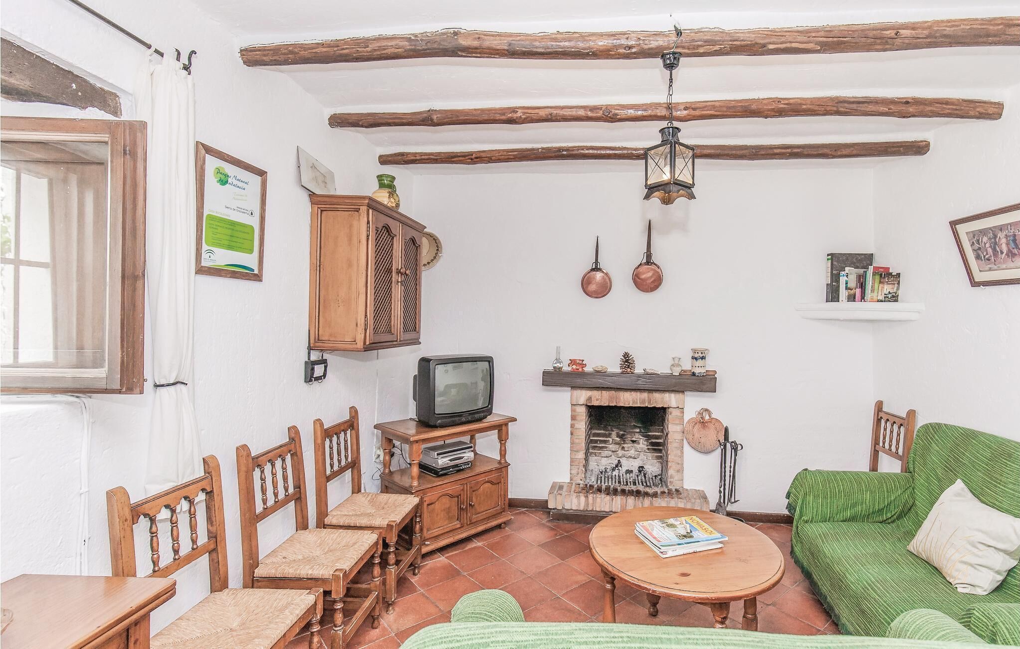 Ein gemütliches Wohnzimmer mit Kamin, Holzmöbeln und einem Fernseher.