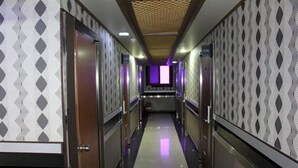 A hotel corridor with patterned walls, a tiled floor, and a central seating area. - Breakfast at Tiffany's Motel (Mokpo)