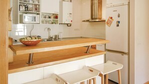 A kitchen with a wooden countertop, a sink, a microwave, and a refrigerator. - 2 bedroom cozy apartment in Llanes (Llanes)