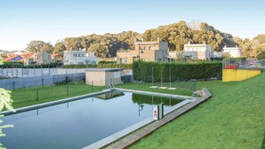 A swimming pool with a surrounding fence, a small building, and a grassy area. - 2 bedroom cozy apartment in Llanes (Llanes)