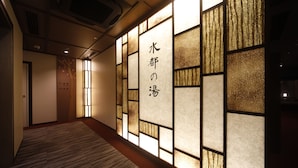 A hallway with a wooden floor and a wall with a decorative panel featuring Japanese characters. - Dormy Inn Premium Osaka Kitahama Hot Springs (Osaka)