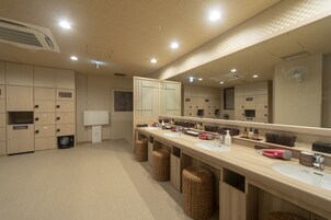 A modern bathroom with multiple sinks, a large mirror, and storage cabinets.