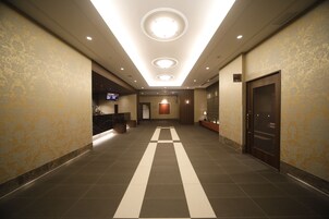 A hotel lobby with a check-in counter, a reception desk, and a reception area.