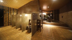 A public restroom with tiled floors, wooden ceiling, and a brick accent wall. - Dormy Inn Premium Osaka Kitahama Hot Springs (Osaka)