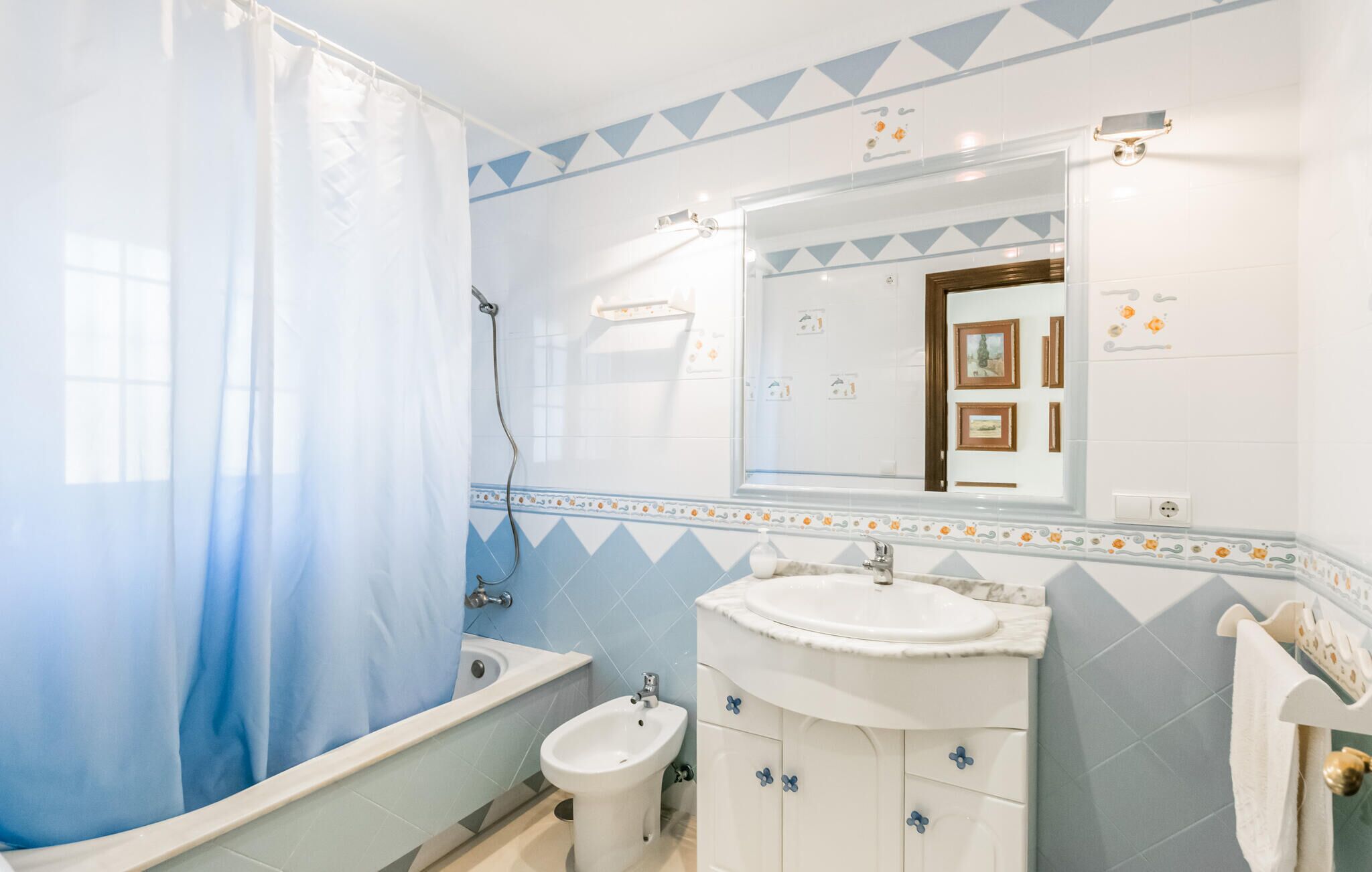 A bathroom with a bathtub, a sink, and a bidet.