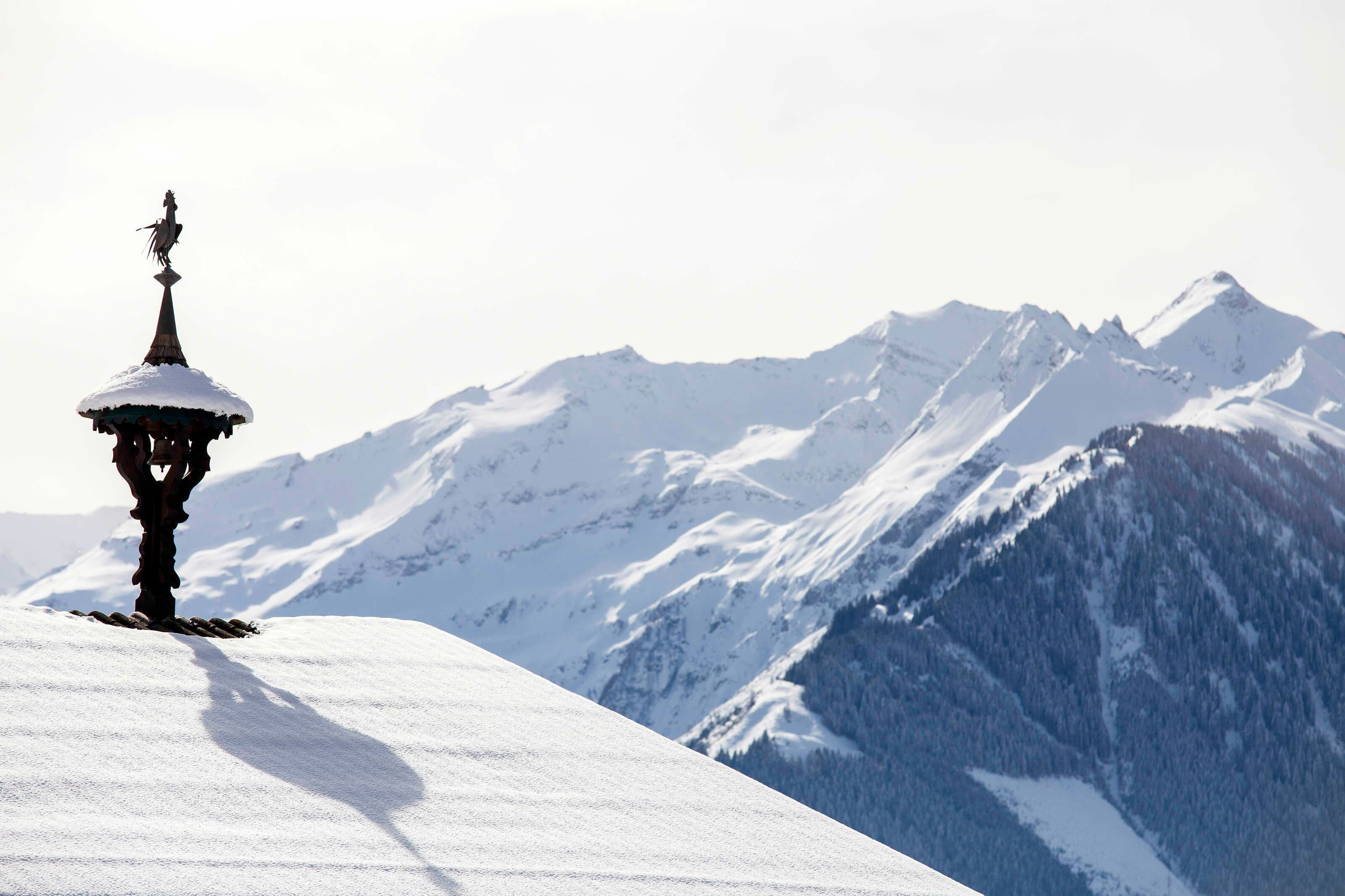 A snow-covered mountain with a statue on a pedestal.