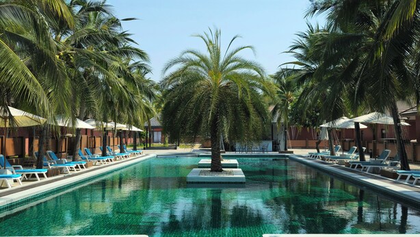 A swimming pool with lounge chairs and palm trees. - Baan Me Suk Spa & Resort Hua-Hin (Cha-am)