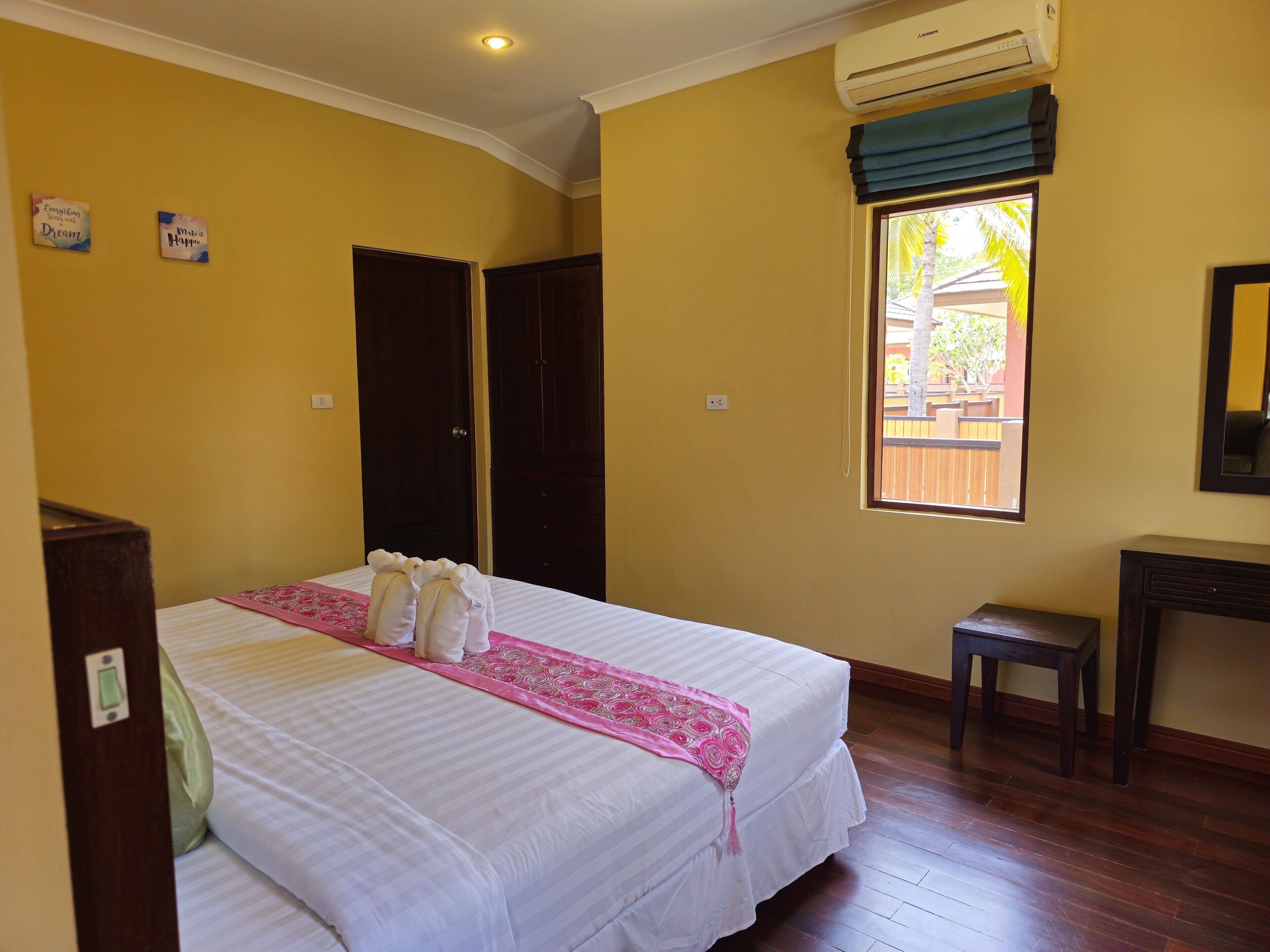 Habitación de hotel con cama, escritorio, ventana con vistas y aire acondicionado.