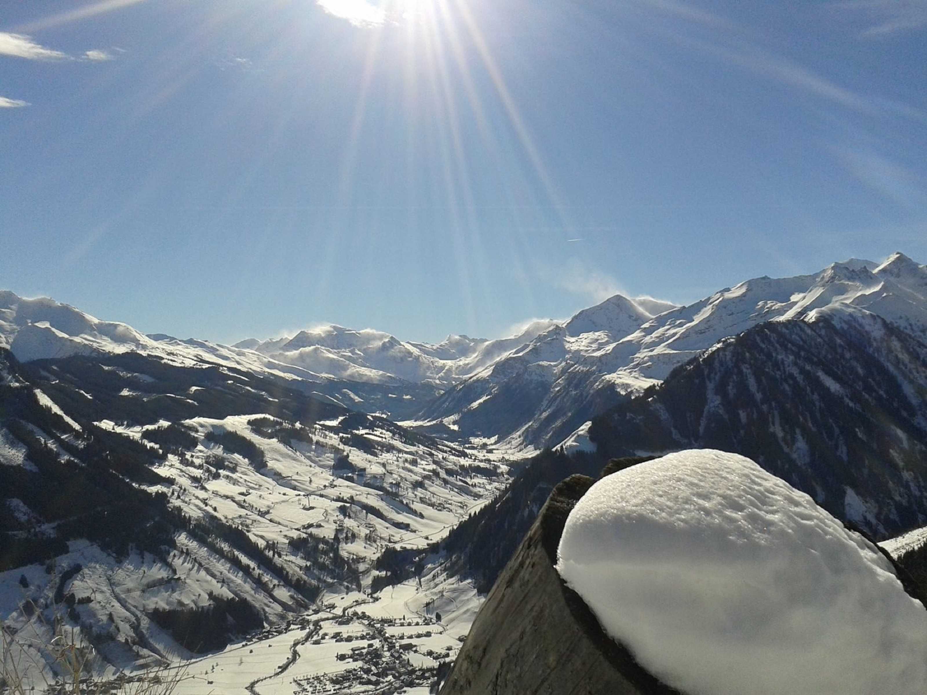 A mountain landscape with snow-covered peaks and a clear sky.