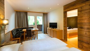 Habitación de hotel con cama, escritorio, silla, televisor y armario.