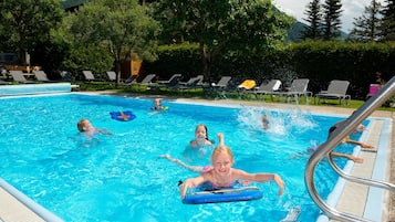 A swimming pool with lounge chairs and a poolside area.