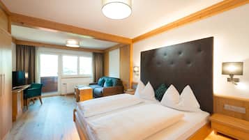 Una habitación de hotel con una cama grande, un escritorio, una silla y un televisor.