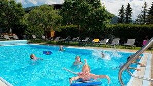 Ein Schwimmbecken mit Liegestühlen und einer Poolanlage.
