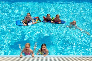A swimming pool with clear blue water and a wooden deck. - Deluxe Stone Pine Room - Hotel Alpina **** (Rauris)