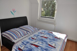 A bedroom with a bed, a window, and a radiator.