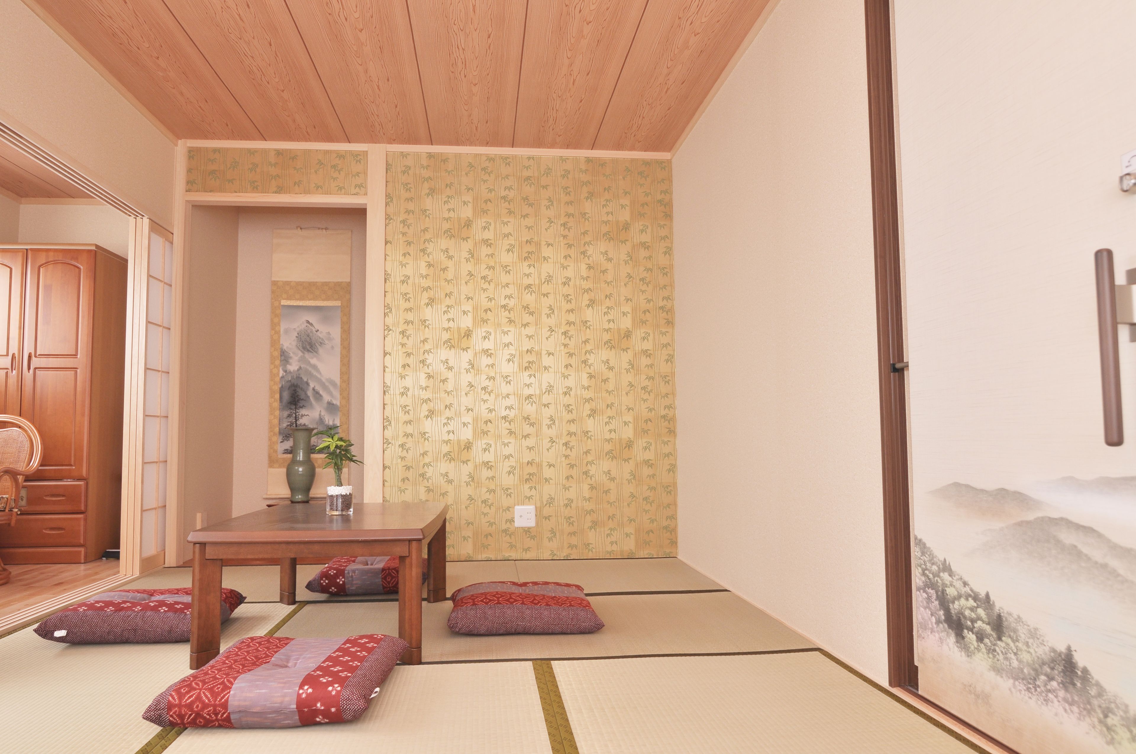 Une pièce de style japonais traditionnel, avec un sol recouvert de tatamis, une petite table basse entourée de coussins et une porte coulissante.