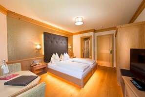 Een hotelkamer met een bed, nachtkastjes, een bureau, een stoel, een televisie en een kledingkast.