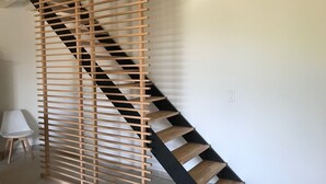 Eine moderne Treppe mit Holzlamellen und schwarzen Stufen, die zu einer oberen Etage führt.