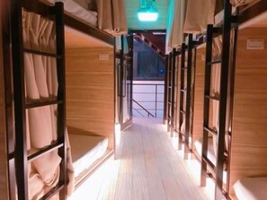 A corridor with bunk beds arranged in a row, wooden walls, and a metal railing at the end. - Box Inn Jiufen - Hostel (New Taipei City)