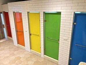 A row of brightly colored doors in a hallway with a tiled floor. - Box Inn Jiufen - Hostel (New Taipei City)