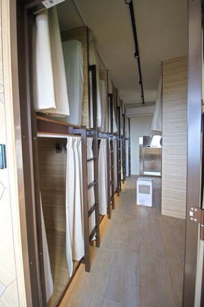A corridor with bunk beds, a kitchenette, and a shower area. - Box Inn Jiufen - Hostel (New Taipei City)