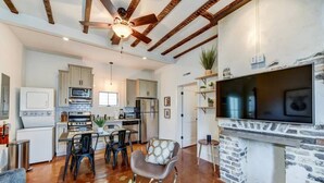 Un amplio salón con una mesa de comedor, sillas, una chimenea y una cocina al fondo.