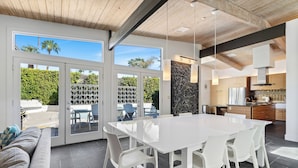 Una cocina moderna con una isla grande, armarios blancos y electrodomésticos de acero inoxidable.