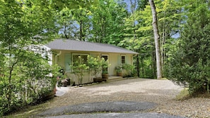 Ein Bungalow mit Schotterweg, umgeben von dichter Baumdecke.