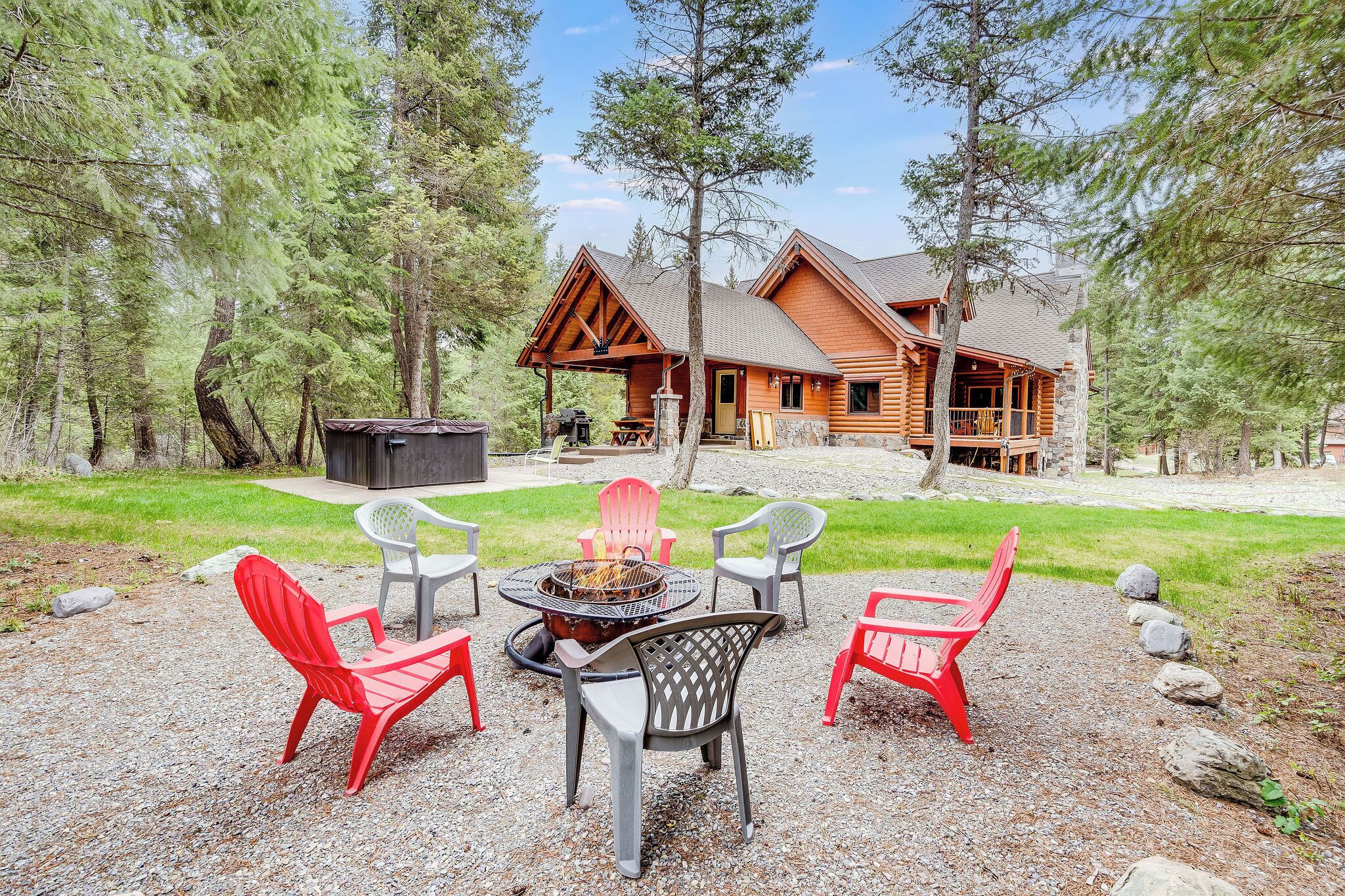 A lodge with a covered outdoor seating area, a fire pit, and a stone patio.