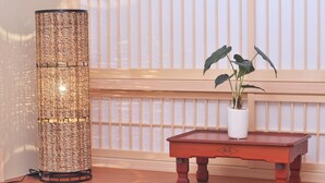 A traditional Japanese-style room with a woven lamp, a small table with a plant, and shoji screens in the background. - Shirakabanoyado-fuka (Osaka)