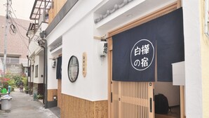 A narrow alley with a traditional Japanese building. A black banner with white text is displayed outside. - Shirakabanoyado-fuka (Osaka)