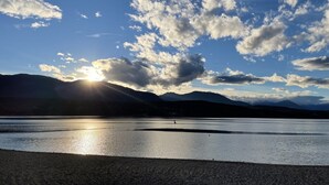 A calm lake with mountains in the background and a clear sky. - Private beach and lake access at Windermere Lake. NEW POOL AND HOT TUB NOW OPEN! (Windermere)