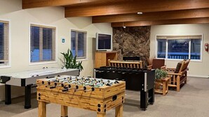 A room with a foosball table, a pool table, and a stone wall. - Private beach and lake access at Windermere Lake. NEW POOL AND HOT TUB NOW OPEN! (Windermere)