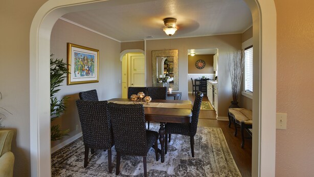 A dining area with a round table, four chairs, and a decorative centerpiece. There is a mirror on the wall, a clock, and a vase with branches. - Shasta Star. Mountain views in downtown Mt. Shasta (Mt Shasta)