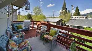 A balcony with wicker chairs and a grill, overlooking a residential area with trees and a mountain in the background. - Shasta Star. Mountain views in downtown Mt. Shasta (Mt Shasta)