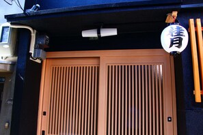A traditional Japanese entrance with sliding doors and a lantern. - Shirakabanoyado-keigetsu (Osaka)