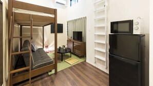 A compact room with a bunk bed, a small desk with a chair, a television, and a refrigerator. - Trip Pod Sumiyoshi A (Fukuoka)