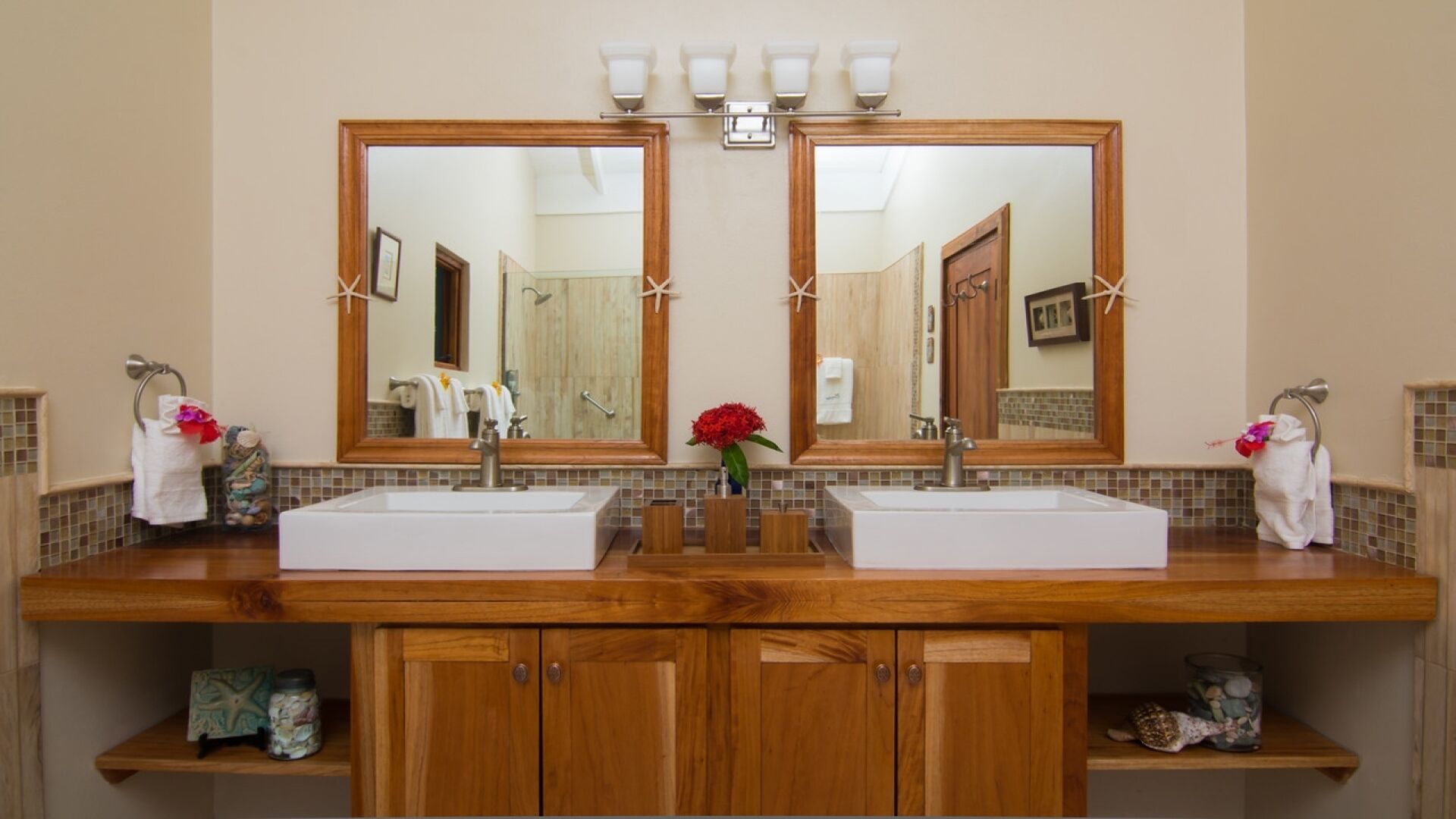 A bathroom with two sinks, wooden cabinets, and a large mirror.
