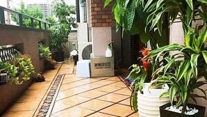 A tiled outdoor area with potted plants and a sign in Japanese. - Shirakabanoyado-Minato (Osaka)
