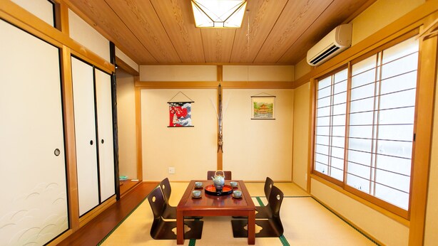 A traditional Japanese room with tatami flooring, a wooden table with a tea set, and sliding doors. - Shirakabanoyado-Minato (Osaka)