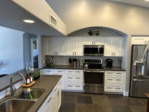 Enjoy cooking in this well-equipped kitchen with a large island, sink, and modern appliances.
