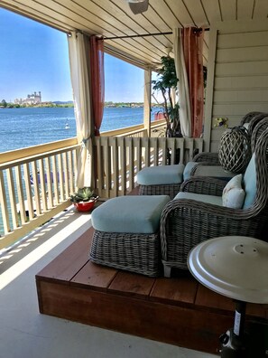 A covered outdoor seating area with wicker furniture and a view of the water. - Adorable waterfront condo, private docks, and bring the dog! (Horseshoe Bay)