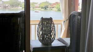 A view from a window with a wicker chair and a decorative vase on a table. - Adorable waterfront condo, private docks, and bring the dog! (Horseshoe Bay)