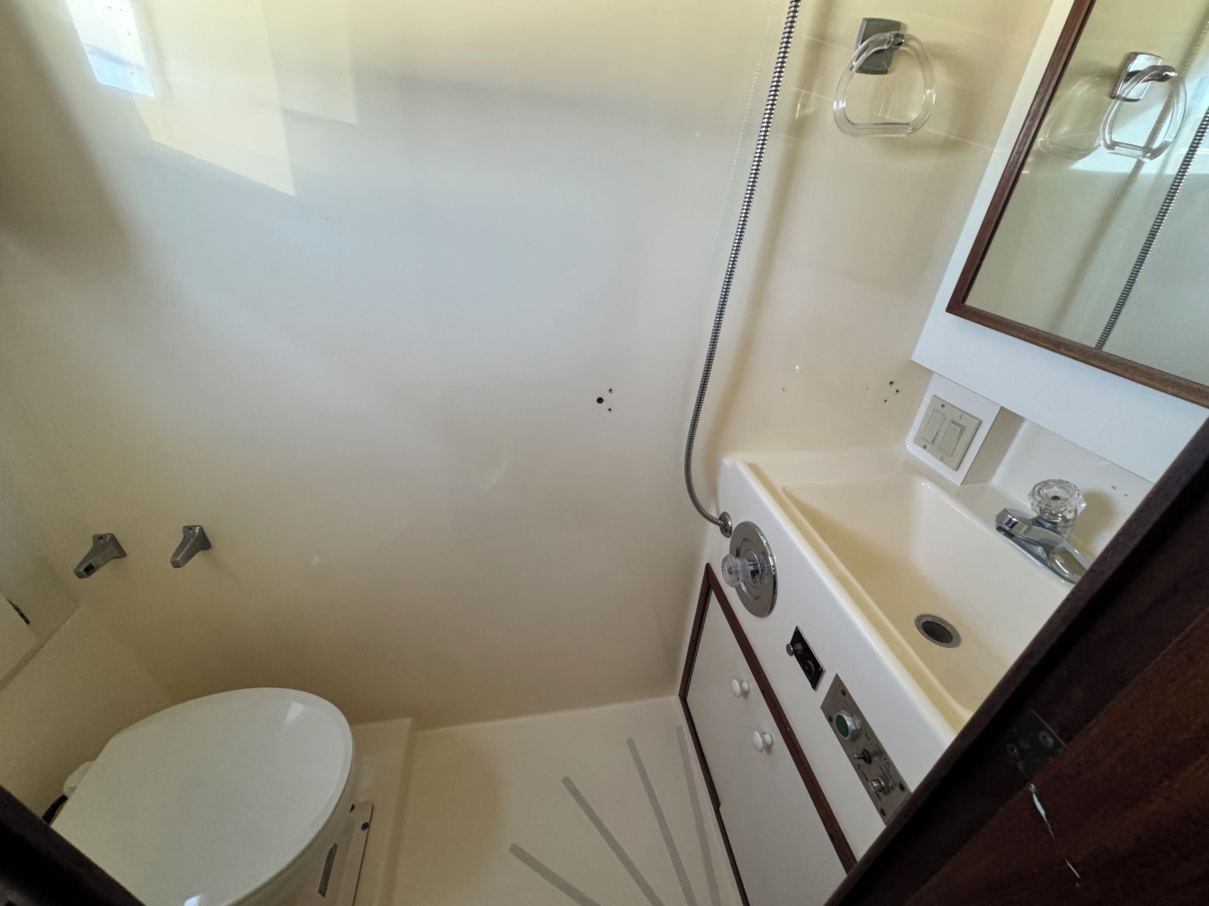 Un bagno piccolo con un WC, un lavandino, uno specchio e una doccia.