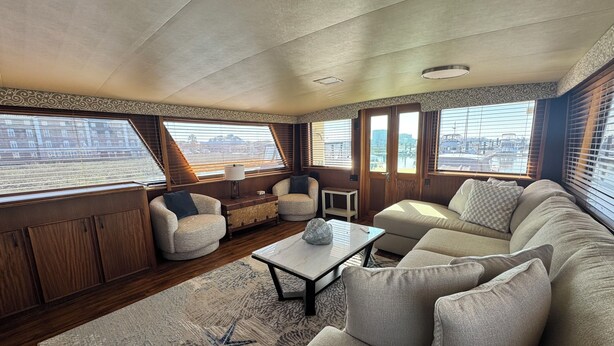 L’intérieur d’un yacht, avec un canapé, des fauteuils, une table basse et un tapis à motifs.